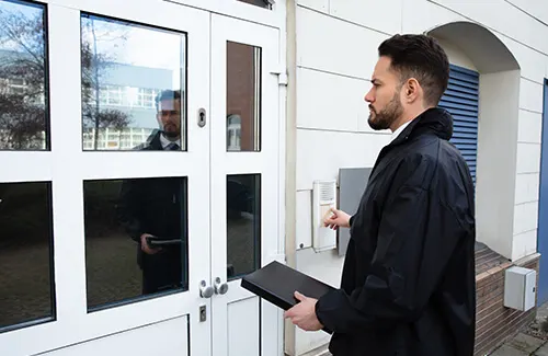 Enforcement officer with a tablet at the door of a property