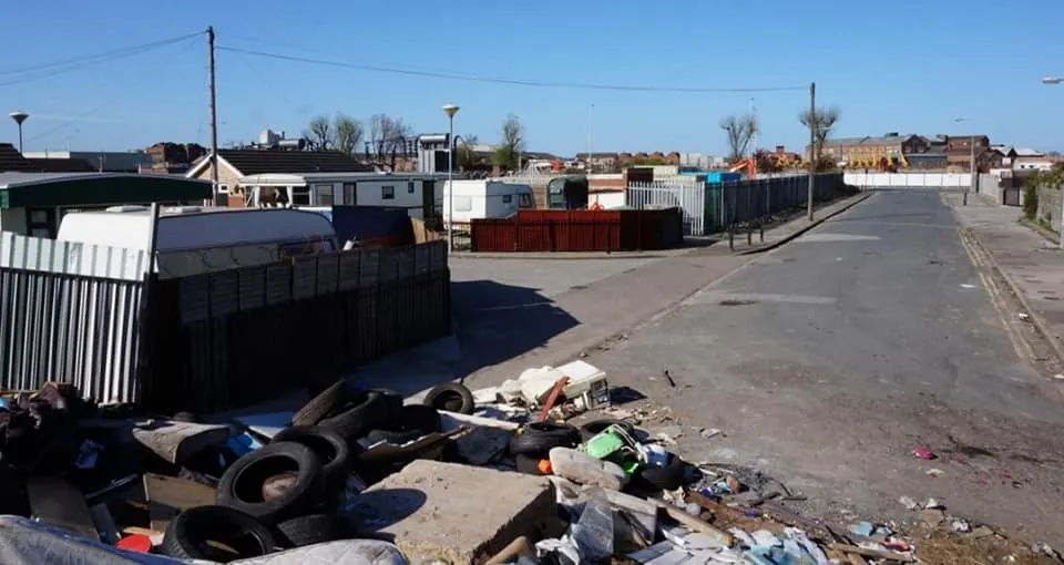 Tyres and rubbish left on the ground at an unauthorised encampment